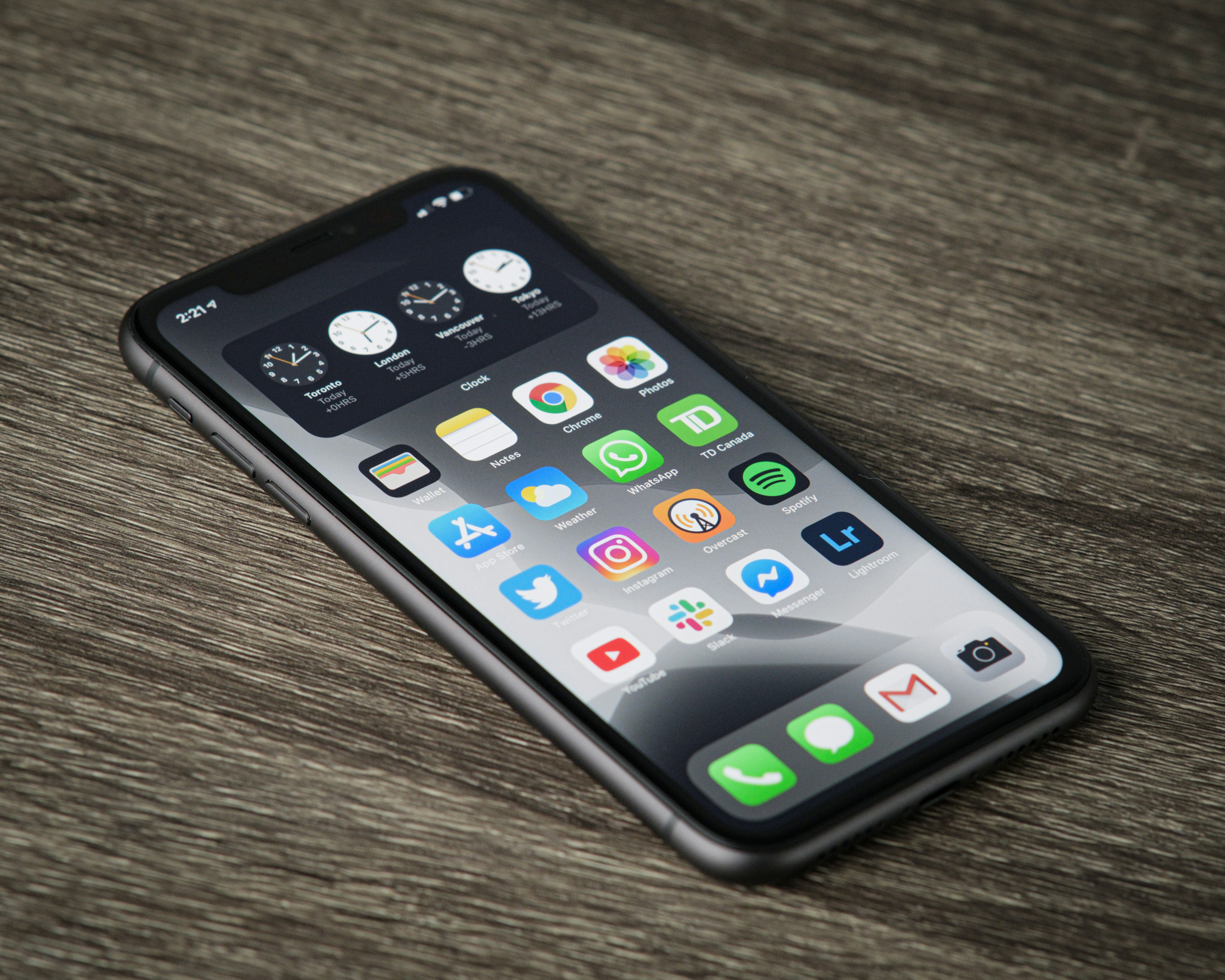 Smartphone with app icons on a wooden table